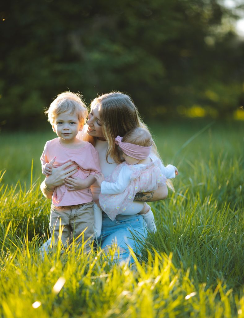 Mother holding two children outdoors representing family healthcare and general practice care